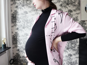 Image of pregnant woman holding her back 